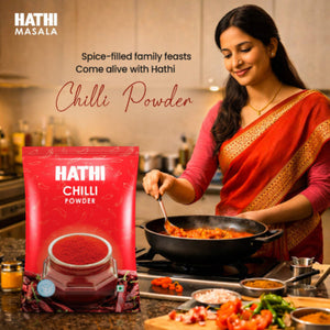 Indian woman in red saree cooking spicy curry in home kitchen using Hathi Chilli Powder for rich flavour and colour